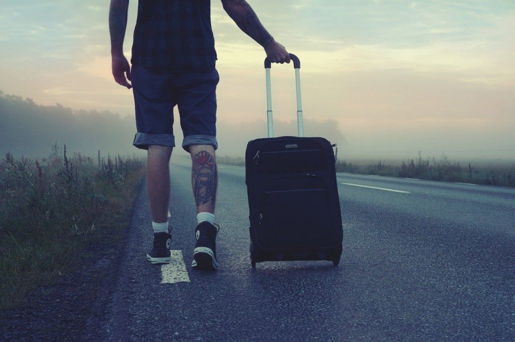 viaggiatore a piedi con una sola valigia